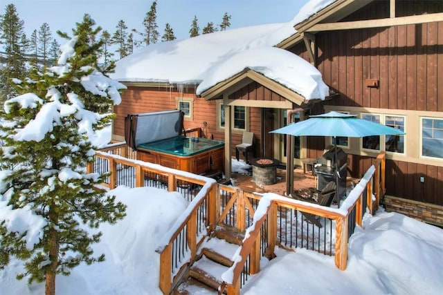 exterior space with board and batten siding, a hot tub, and a wooden deck