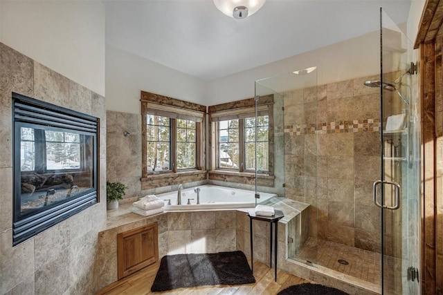 bathroom featuring a shower stall and a bath