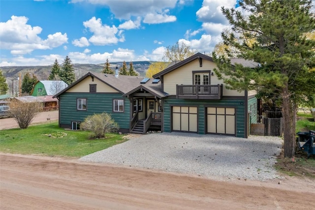 77 Lincoln St, Yampa, CO 80483 - view of front of home featuring gravel driveway, a balcony, an attached garage, a front lawn, and french doors