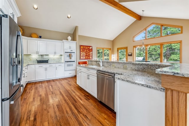 1118 Penstemon Rd, Dillon, CO 80435 - kitchen with appliances with stainless steel finishes, a sink, light wood-style flooring, beamed ceiling, and white cabinetry