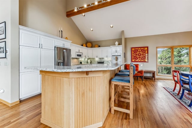 1118 Penstemon Rd, Dillon, CO 80435 - kitchen with white appliances, light wood-style floors, white cabinets, decorative backsplash, and beam ceiling