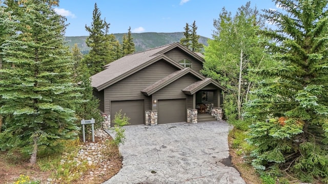 1118 Penstemon Rd, Dillon, CO 80435 - view of front of home featuring driveway, stone siding, an attached garage, and a mountain view