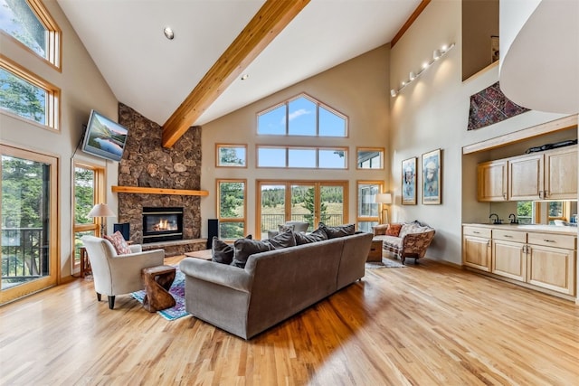 1118 Penstemon Rd, Dillon, CO 80435 - living room featuring high vaulted ceiling, light wood finished floors, beam ceiling, a stone fireplace, and baseboards