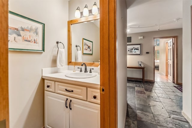 1118 Penstemon Rd, Dillon, CO 80435 - bathroom with stone tile flooring, vanity, baseboards, and track lighting