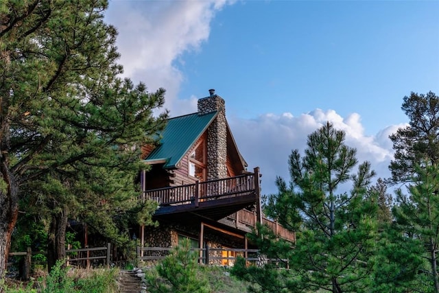 664 Tonkawa Rd, Hartsel, CO 80449 - rear view of property featuring a wooden deck, a chimney, log siding, and a metal roof