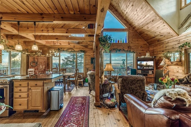 664 Tonkawa Rd, Hartsel, CO 80449 - living room featuring a wooden ceiling with exposed beams, wooden walls, light wood-style floors, and a towering ceiling