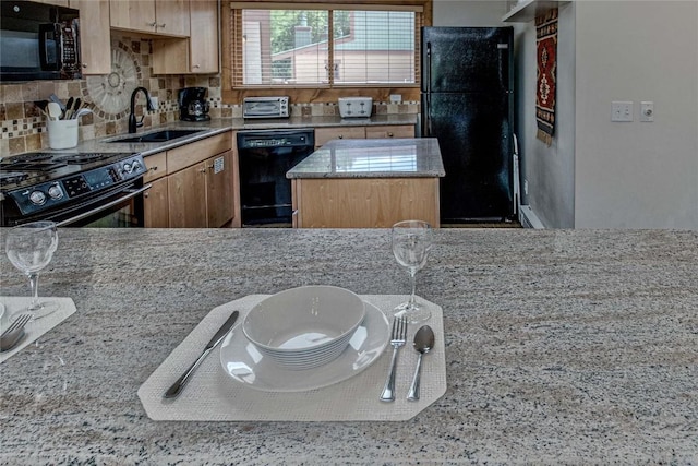 kitchen with sink, a kitchen island, and black appliances