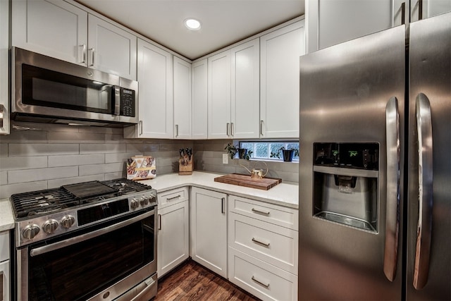 7 Lookout Ridge Dr Unit 7, Dillon, CO 80435 - kitchen featuring stainless steel appliances, light countertops, dark wood finished floors, decorative backsplash, and white cabinetry