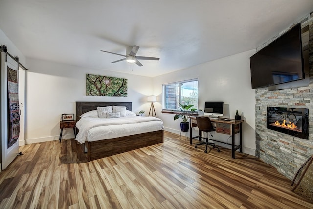 7 Lookout Ridge Dr Unit 7, Dillon, CO 80435 - bedroom with a stone fireplace, wood finished floors, baseboards, and ceiling fan