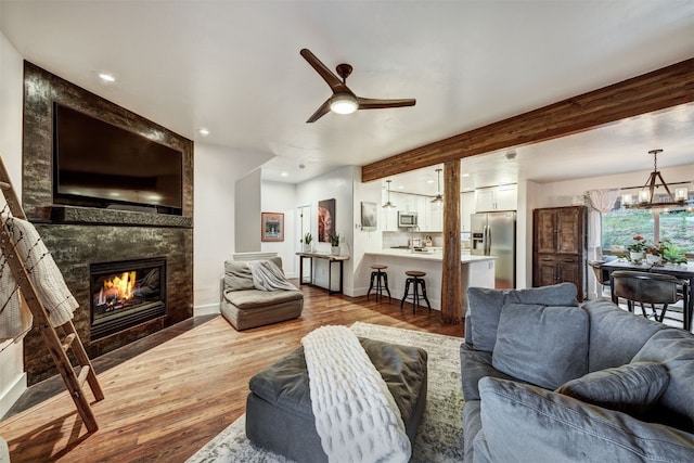 7 Lookout Ridge Dr Unit 7, Dillon, CO 80435 - living area featuring a tiled fireplace, wood finished floors, a chandelier, a ceiling fan, and recessed lighting
