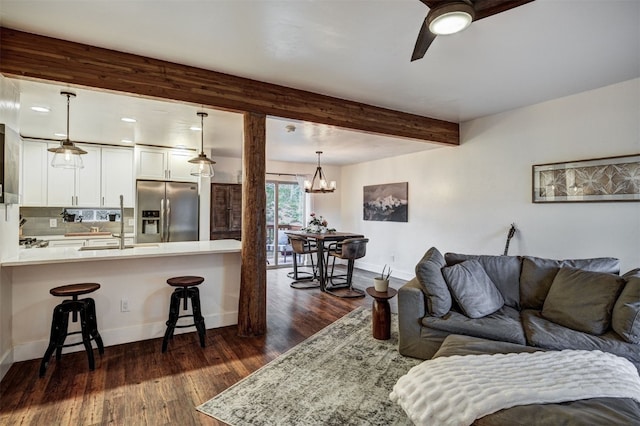 7 Lookout Ridge Dr Unit 7, Dillon, CO 80435 - living area featuring baseboards, dark wood-style flooring, a chandelier, ceiling fan, and beam ceiling