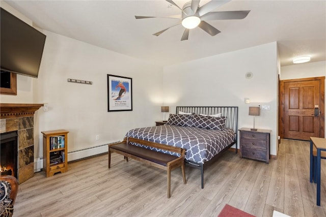 505A S Main St Unit 1204, Breckenridge, CO 80424 - bedroom with a tiled fireplace, light wood-style flooring, and baseboard heating