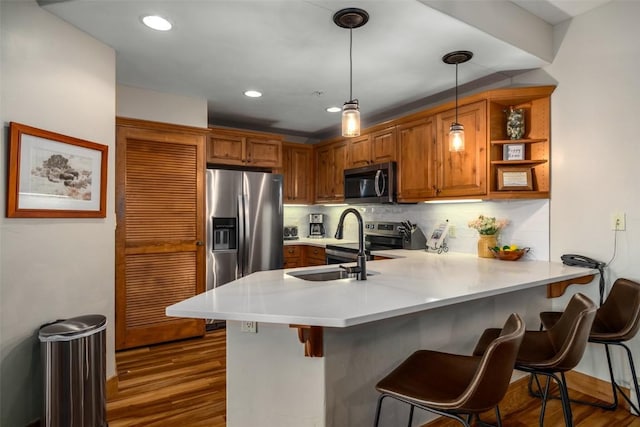 1463 Flattop Cir Unit 204, Steamboat Springs, CO 80487 - kitchen featuring a breakfast bar, stainless steel appliances, a peninsula, brown cabinetry, and backsplash