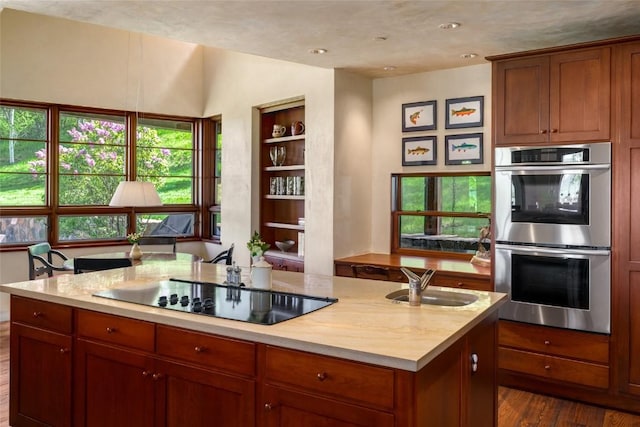 33225 Painted Pony Ln, Steamboat Springs, CO 80487 - kitchen with double oven, black electric stovetop, a center island, dark wood finished floors, and brown cabinets
