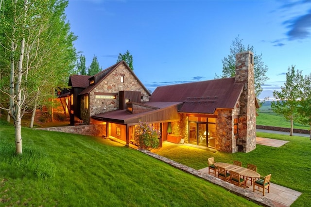 33225 Painted Pony Ln, Steamboat Springs, CO 80487 - rear view of property with stone siding, a lawn, and a chimney