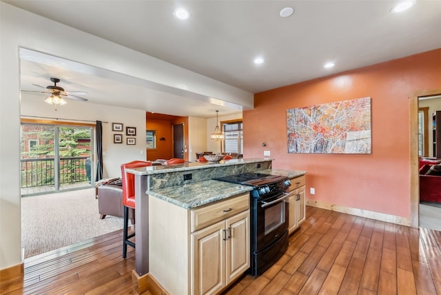 200 Rachel Ln, Breckenridge, CO 80424 - kitchen featuring black range with electric stovetop, light wood-style floors, baseboards, a kitchen breakfast bar, and open floor plan