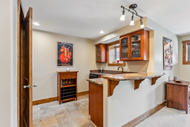 200 Rachel Ln, Breckenridge, CO 80424 - kitchen with brown cabinets, a breakfast bar, stone countertops, baseboards, and recessed lighting
