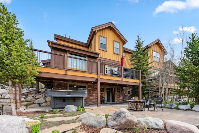 200 Rachel Ln, Breckenridge, CO 80424 - back of house featuring board and batten siding, a fire pit, a patio area, stone siding, and a wooden deck