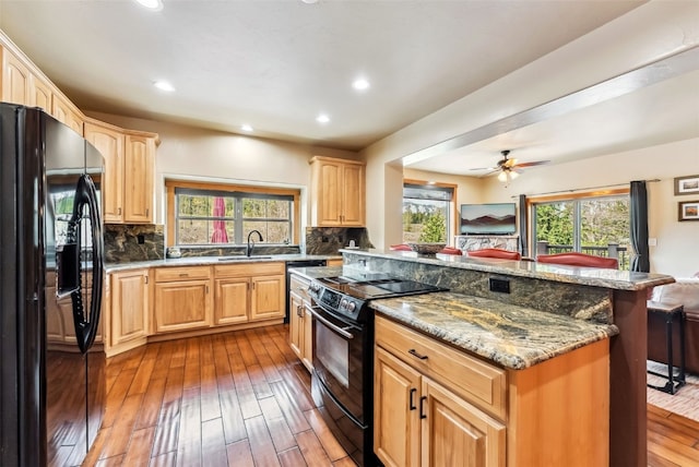 200 Rachel Ln, Breckenridge, CO 80424 - kitchen with black appliances, light brown cabinets, wood-type flooring, a kitchen island, and recessed lighting
