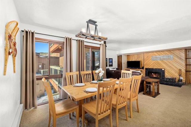 dining area with carpet floors and a lit fireplace