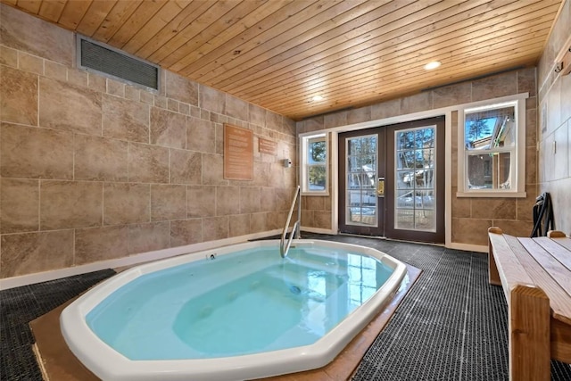 view of swimming pool featuring an indoor hot tub and french doors