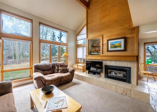 carpeted living room with high vaulted ceiling and a tile fireplace
