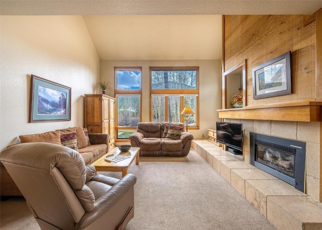 living room with carpet flooring, lofted ceiling, and a tile fireplace