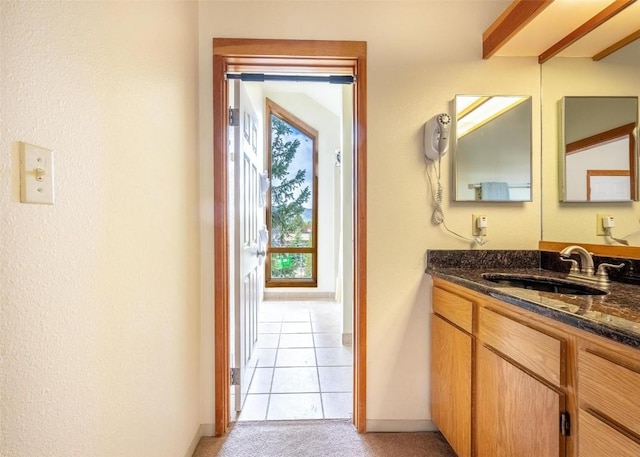 bathroom with baseboards, tile patterned floors, and vanity