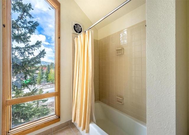 bathroom with tile patterned floors, lofted ceiling, shower / bathtub combination with curtain, and visible vents