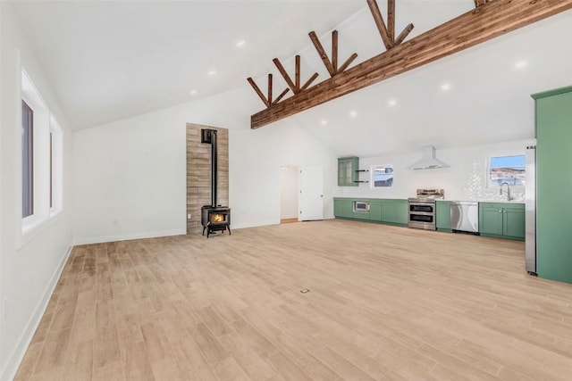 32655 County Road 179, Oak Creek, CO 80467 - unfurnished living room with a wood stove, a sink, beamed ceiling, light wood-type flooring, and high vaulted ceiling