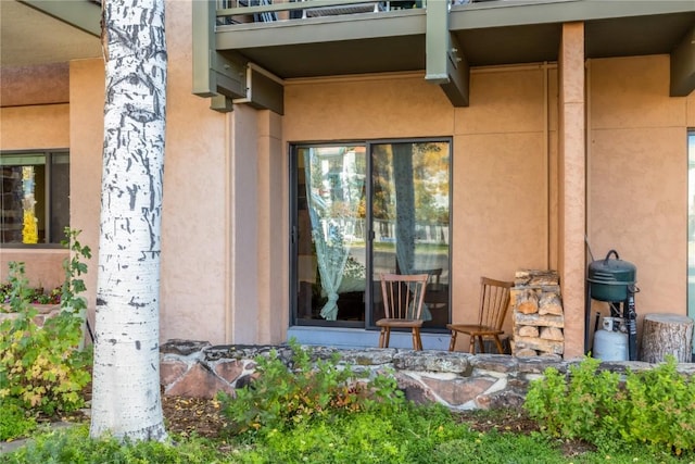 doorway to property with stucco siding and a balcony