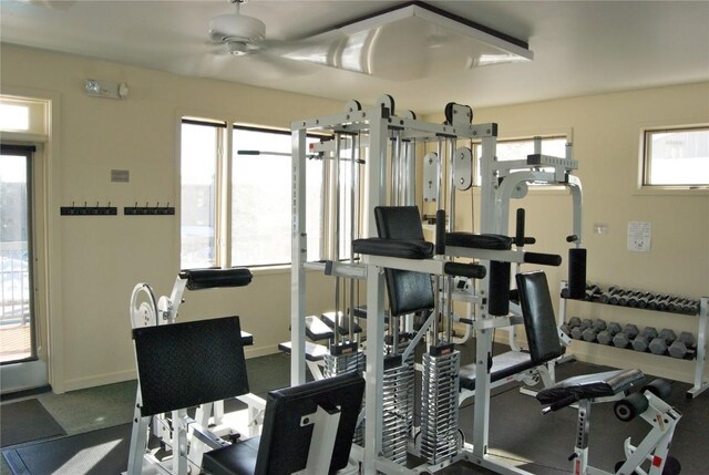 workout area with a ceiling fan, baseboards, and a healthy amount of sunlight