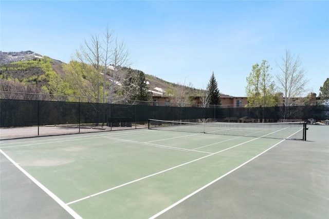 view of sport court with fence and a mountain view