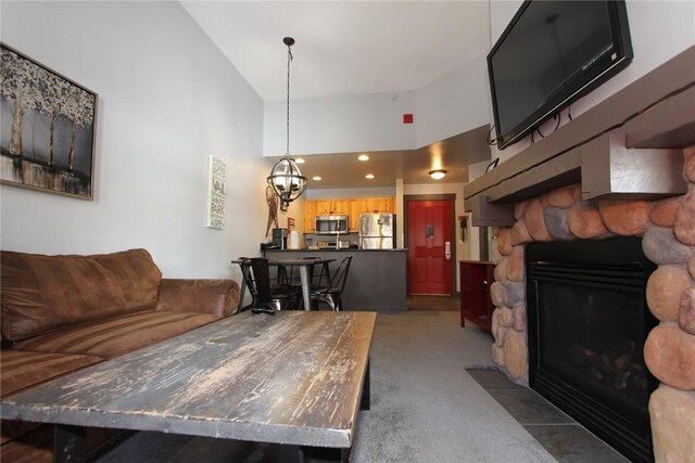 172 Copper Cir Unit 101, Copper Mountain, CO 80443 - living area featuring a fireplace, carpet flooring, high vaulted ceiling, and an inviting chandelier