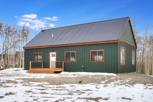 snow covered rear of property featuring metal roof