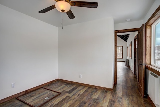 unfurnished room featuring a ceiling fan, lofted ceiling, radiator heating unit, and wood finished floors