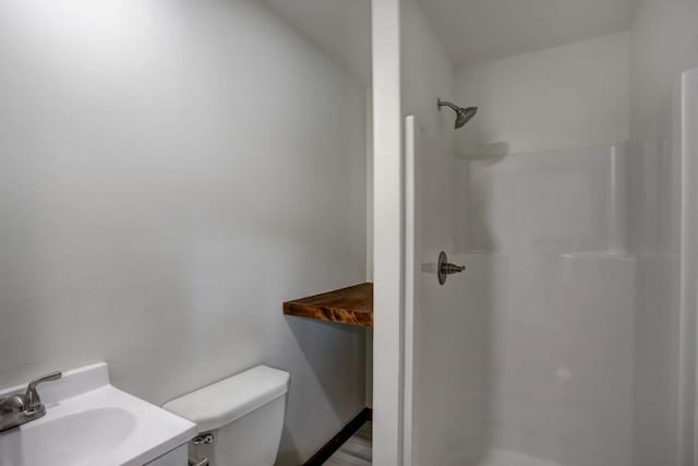 bathroom with vanity, a walk in shower, and toilet