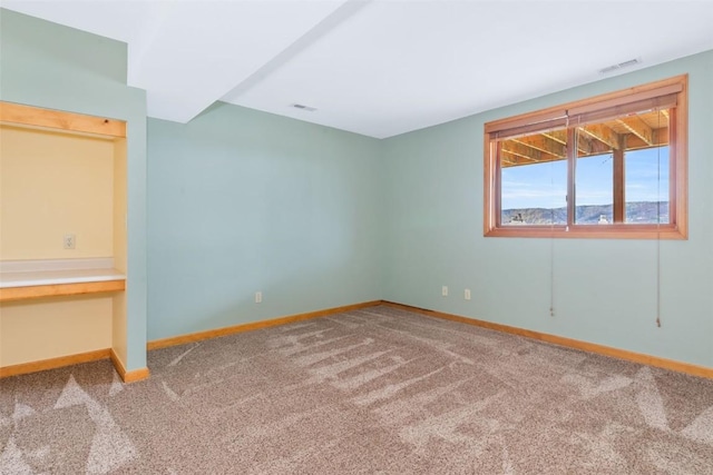 unfurnished bedroom with carpet flooring, baseboards, and visible vents