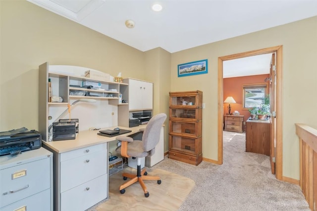 home office with baseboards and light colored carpet