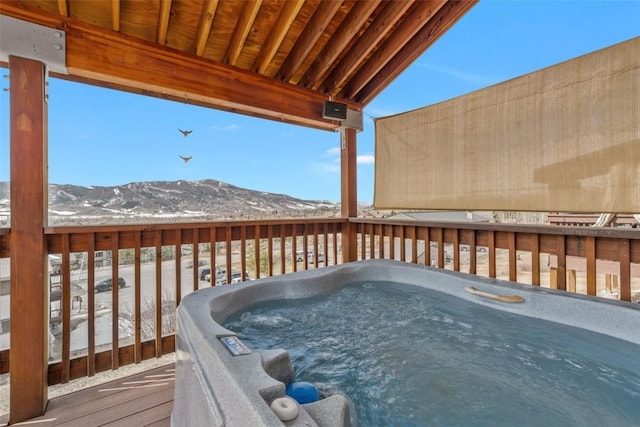 wooden terrace featuring a mountain view and a hot tub