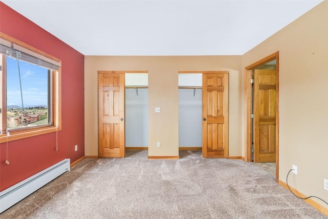 unfurnished bedroom featuring two closets, carpet flooring, baseboards, and a baseboard radiator