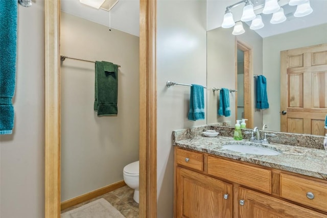 bathroom with vanity, baseboards, and toilet