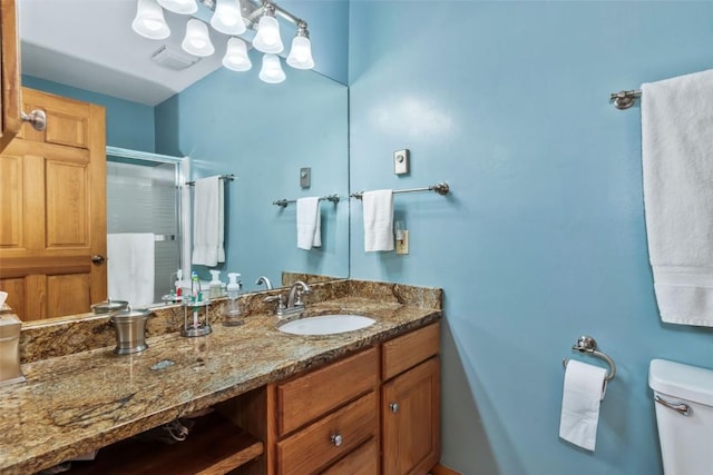 full bath featuring vanity, toilet, and a shower stall