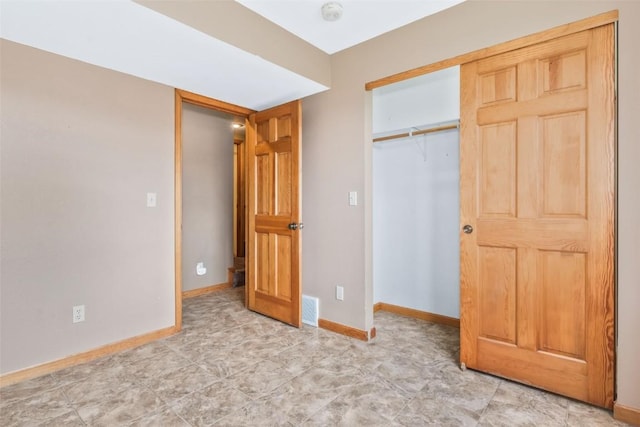 unfurnished bedroom featuring baseboards, visible vents, and a closet