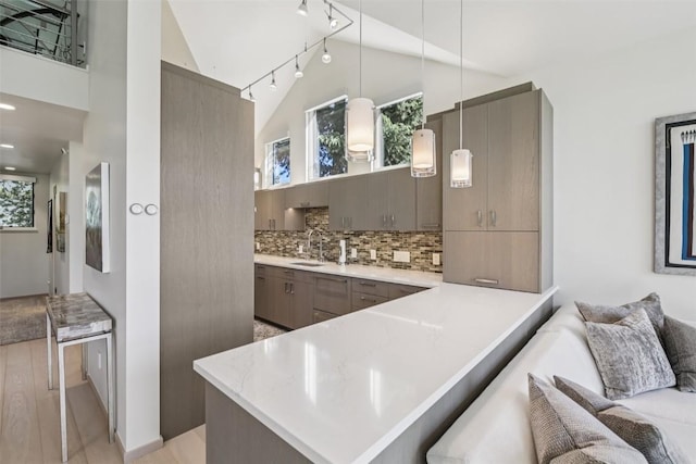 405 Creekside Dr, Frisco, CO 80443 - kitchen with a peninsula, light countertops, a breakfast bar, tasteful backsplash, and modern cabinets
