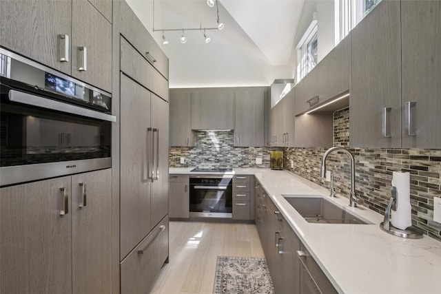405 Creekside Dr, Frisco, CO 80443 - kitchen with stainless steel oven, backsplash, light wood-style floors, modern cabinets, and high vaulted ceiling