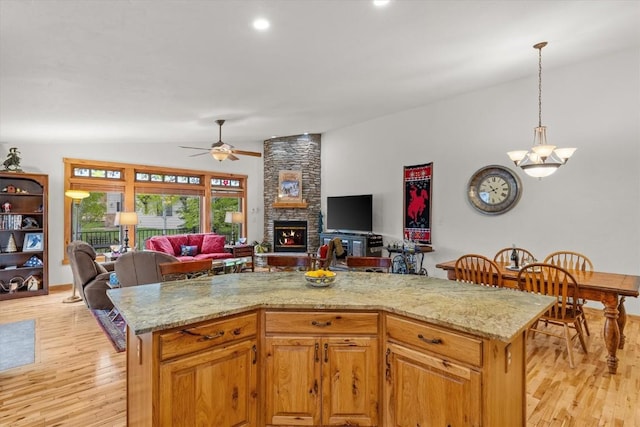 1088 Longview Cir Unit 1, Steamboat Springs, CO 80487 - kitchen featuring open floor plan, vaulted ceiling, light wood-style floors, a ceiling fan, and a fireplace