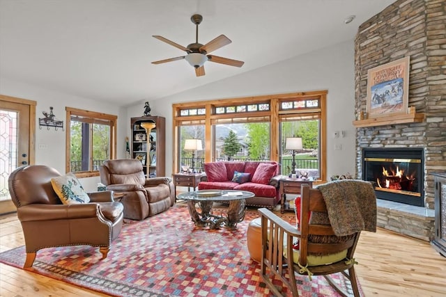 1088 Longview Cir Unit 1, Steamboat Springs, CO 80487 - living area with lofted ceiling, a stone fireplace, a ceiling fan, and light wood-style flooring