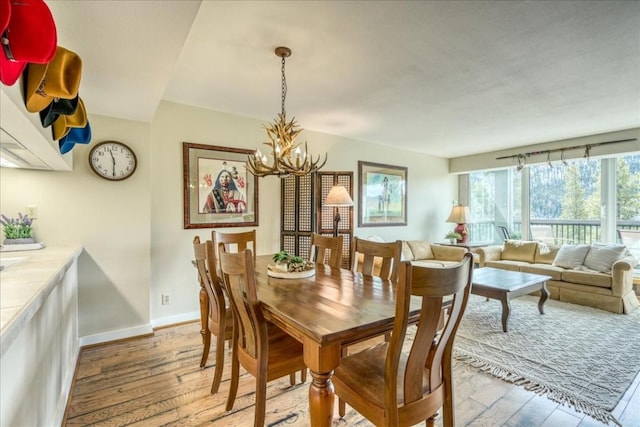 dining room with hardwood / wood-style floors, baseboards, and a chandelier