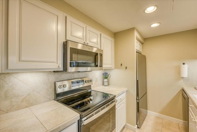 kitchen featuring tasteful backsplash, appliances with stainless steel finishes, light countertops, white cabinetry, and recessed lighting
